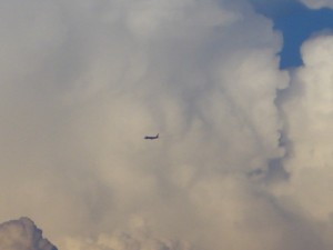積乱雲の前を飛ぶ飛行機